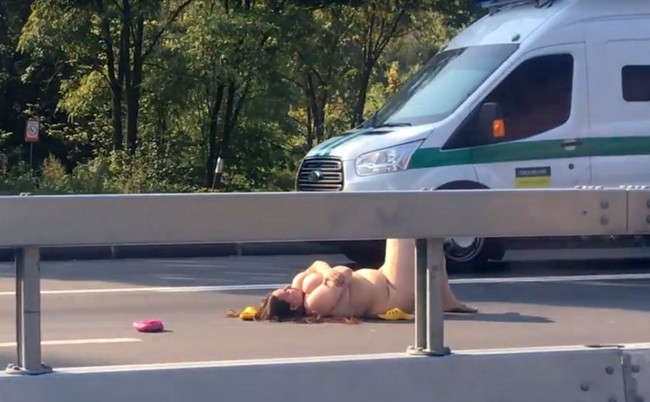 Голая девушка легла прямо на проезжей части (видео)